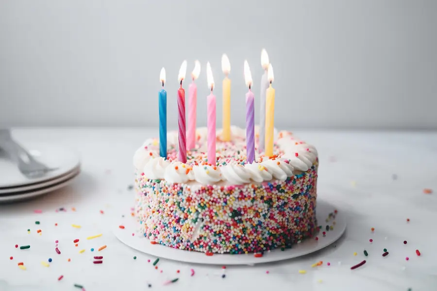 Pastel de cumpleaños con velas y chispas de colores