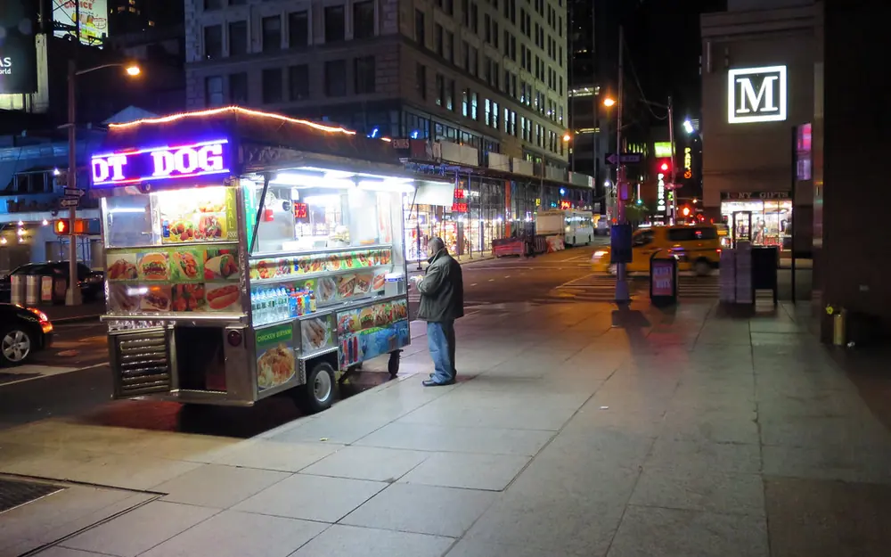 Carrito de hot dogs en la calle durante la noche