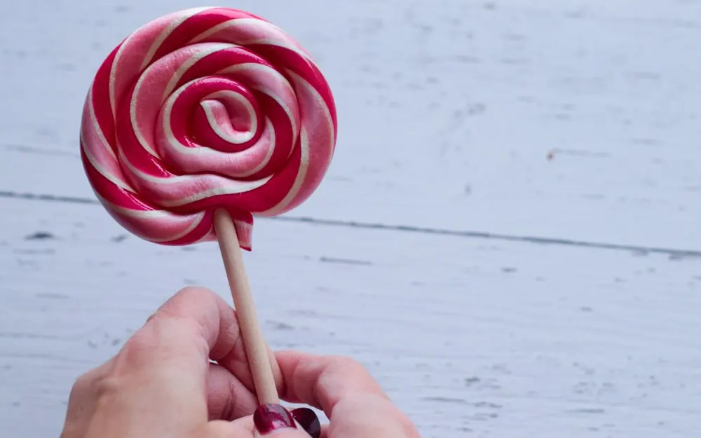 Paleta de caramelo en espiral sostenida a mano